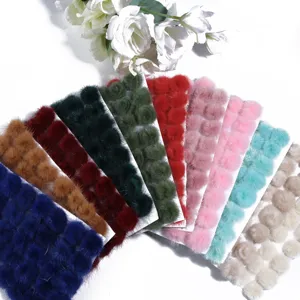 Colorful mink fur pom poms detail view, soft plush balls for apparel and crafts making.