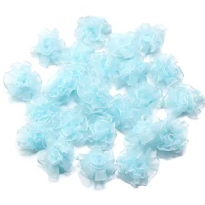 Gros plan sur les fleurs d'œillet en organza bleu clair 3.5cm pour accessoires et loisirs.
