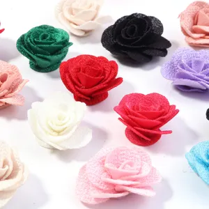 Primo piano di vari fiori di rosa in tessuto colorato, ideali per accessori fai da te.