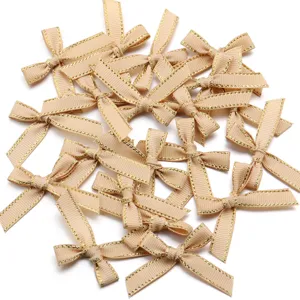 Gedetailleerd overzicht van champagne polyester grosgrain lint strikken met goudrand.