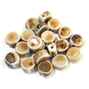 Vista dettagliata di perline piatte tonde in ceramica smaltata per creazione gioielli.