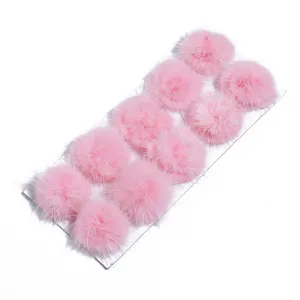 Detail view of pink fluffy fur pom poms accessory, soft texture for DIY crafts and decor.