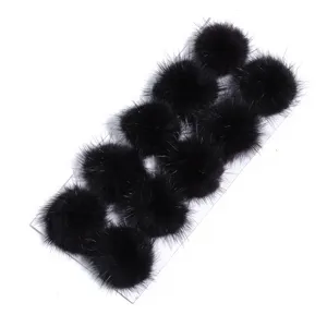 Detailed view of fluffy black mink fur pom poms arranged neatly for DIY crafting and accessories.