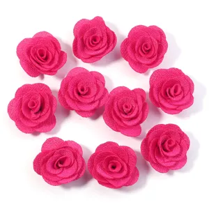 Vista di dettaglio di rose in tessuto rosa, accessori fai da te in lino perlato per borse e abiti.