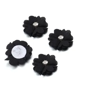 Closeup view of black fabric flower rhinestone craft accessories for handmade DIY sewing and decor.