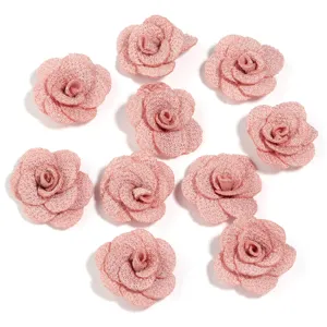 Primo piano dettagliato di fiori di rosa in tessuto rosa luccicante, ideale per accessori fai da te.