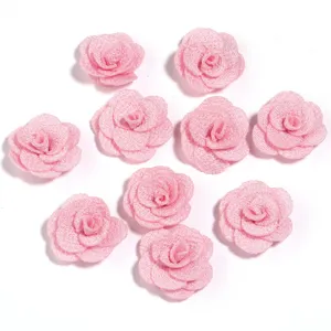 Applicazioni di fiori di rosa in tessuto rosa con finitura glitterata, ideali per fai-da-te.