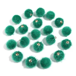 Green faux fur pom poms with golden hanging loops for DIY jewelry keychains and crafts.