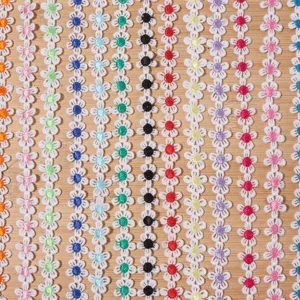 Close-up detail of colorful daisy lace trim, intricate hollow embroidery for apparel DIY.