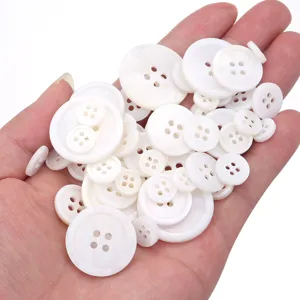 Detail shot of white mother-of-pearl 4-hole round buttons, perfect for shirts and DIY crafts.