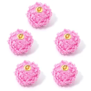 Primer plano detallado de pompones de lana rizada rosa con anilla dorada para joyas DIY.