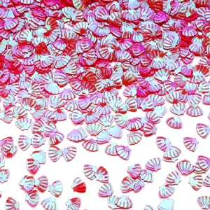 Dettaglio di paillettes in PVC a forma di conchiglia rosa per nail art e accessori fai da te.