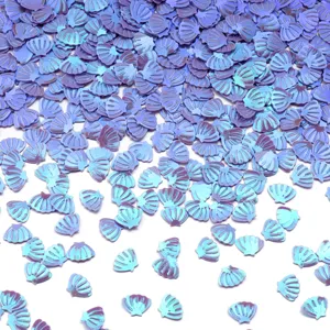 Primo piano di paillettes in PVC a forma di conchiglia iridescente blu per nail art e fai da te
