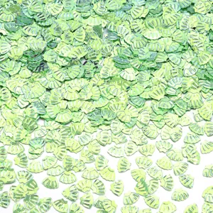 Primo piano dettagliato di paillettes a conchiglia verde lucido, ideali per nail art e fai da te.