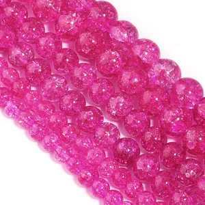Primo piano di perline in cristallo crepato rosa vivo, accessori per gioielli fai da te.