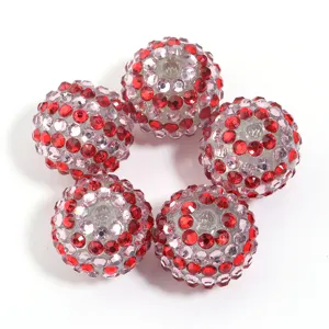 Close-up details of sparkling red and pink rhinestone resin beads for DIY craft projects.