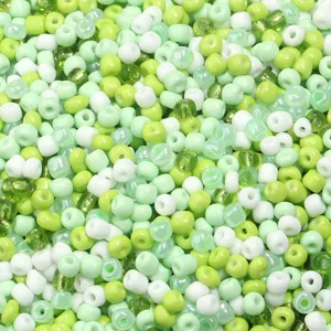 Close-up detail of mixed green and white glass seed beads, perfect for DIY jewelry and crafts.