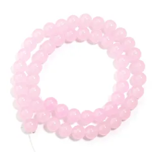 Vista dettagliata di perline rotonde in vetro rosa per la creazione di braccialetti.