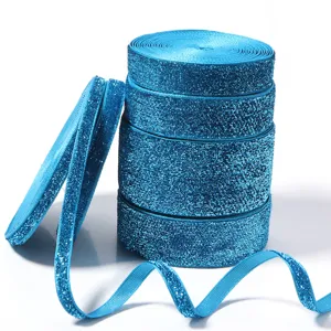 Close-up detail of glittering blue elastic ribbon rolls, shiny tinsel fabric trim for DIY crafts.