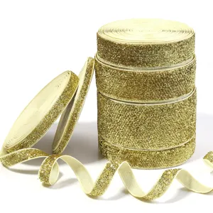Close-up detail of shiny gold glitter elastic ribbon, showing sparkly metallic texture and waves.