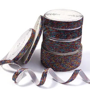 Closeup detail of colorful glitter elastic ribbon rolls, shiny tinsel trim for DIY crafts.