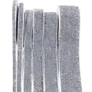 Close-up of silver glitter ribbon rolls in various widths, perfect for DIY crafts and wrapping.