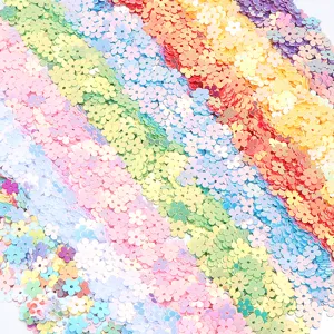 Gros plan detaille de paillettes en forme de fleurs en PVC pour le bricolage d'ongles.