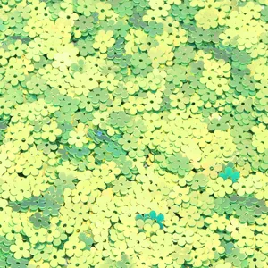 Close up shot of glossy green flower PVC sequins, ideal for DIY nail art and crafts.