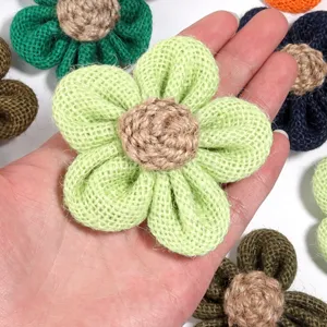 Close-up of handmade light green burlap flower accessory, perfect for DIY crafts and decor.