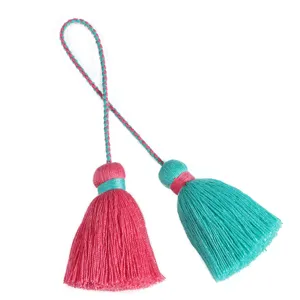 Close-up of bohemian double-head decorative tassels with vibrant pink and turquoise thread.