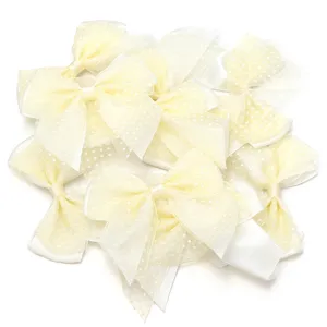 Closeup detail of light yellow polka dot mesh double layer hair bows for DIY craft accessories.