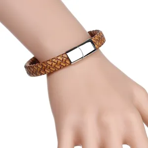 Gedetailleerde close-up van een bruine gevlochten leren armband met stalen sluiting.