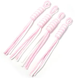 Close-up detail of pink and white woven phone charm lanyard strap DIY craft accessories material.