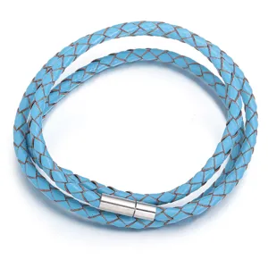 Detalle de pulsera envolvente de cuero trenzado azul claro con textura y cierre metálico.