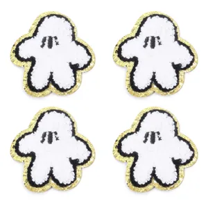 Vista dettagliata della patch ricamata fantasma bianco con bordo glitter dorato, accessorio.
