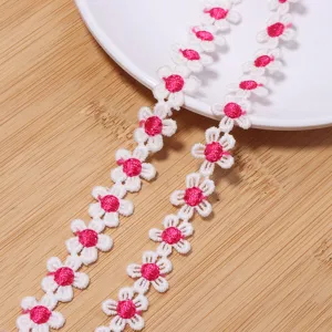 Close-up view of delicate white and pink daisy lace trim, perfect for DIY sewing crafts.