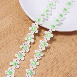 Close-up detail of white and green daisy water-soluble lace trim, delicate embroidery craft.