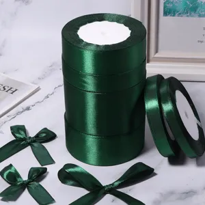 Rotoli di nastro raso verde scuro e fiocchi fatti a mano per regali, matrimoni e fai da te.