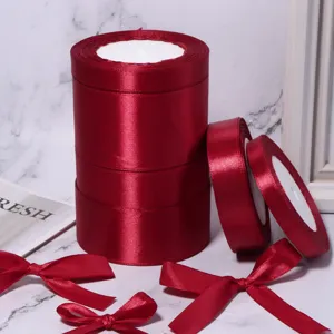 Rotoli di nastro in raso rosso e fiocchi per confezioni regalo e decorazioni per matrimoni.