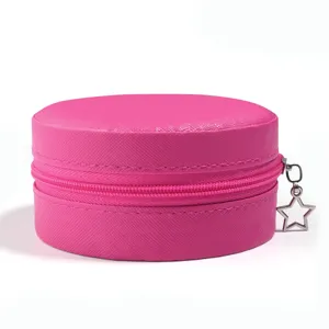 Detailopname van roze ronde PU lederen sieradendoos met zilveren ster rits hanger.