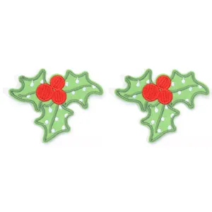 Close-up detail of Christmas holly embroidered iron-on patch, festive fabric DIY accessory.