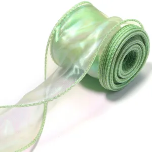 Detail view of iridescent green fish-tail ribbon, sparkling translucent organza for gift.
