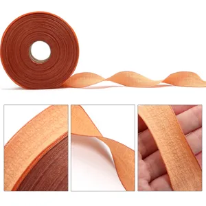 Orange polyester ruffled crinkle ribbon spool for gift wrapping, bows, and craft decoration.