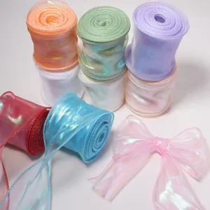 Closeup detail of iridescent wave fish tail yarn ribbon rolls and bow for gift wrapping decor.