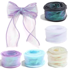 Close up of iridescent wavy organza ribbon rolls and bow in multi colors for gift wrapping.