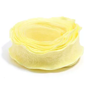 Close-up of yellow ruffled polyester ribbon, detailed texture view for crafts and bows.