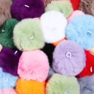 Colorful fluffy fur pom pom keychains and charms with hanging loops for DIY crafts and accessories.