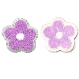 Vista dettagliata di simpatiche toppe ricamate a fiore con sfondo glitterato brillante.