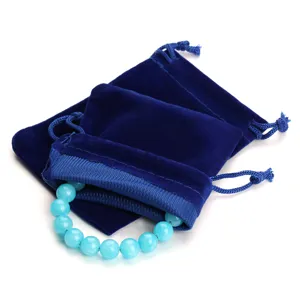 Primo piano dettagliato di morbido sacchetto in velluto blu e bracciale di perle.