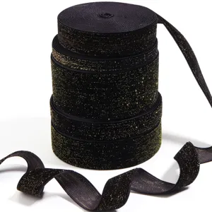 Close-up detail of black gold metallic velvet ribbon rolls for gift wrapping and hair bows.